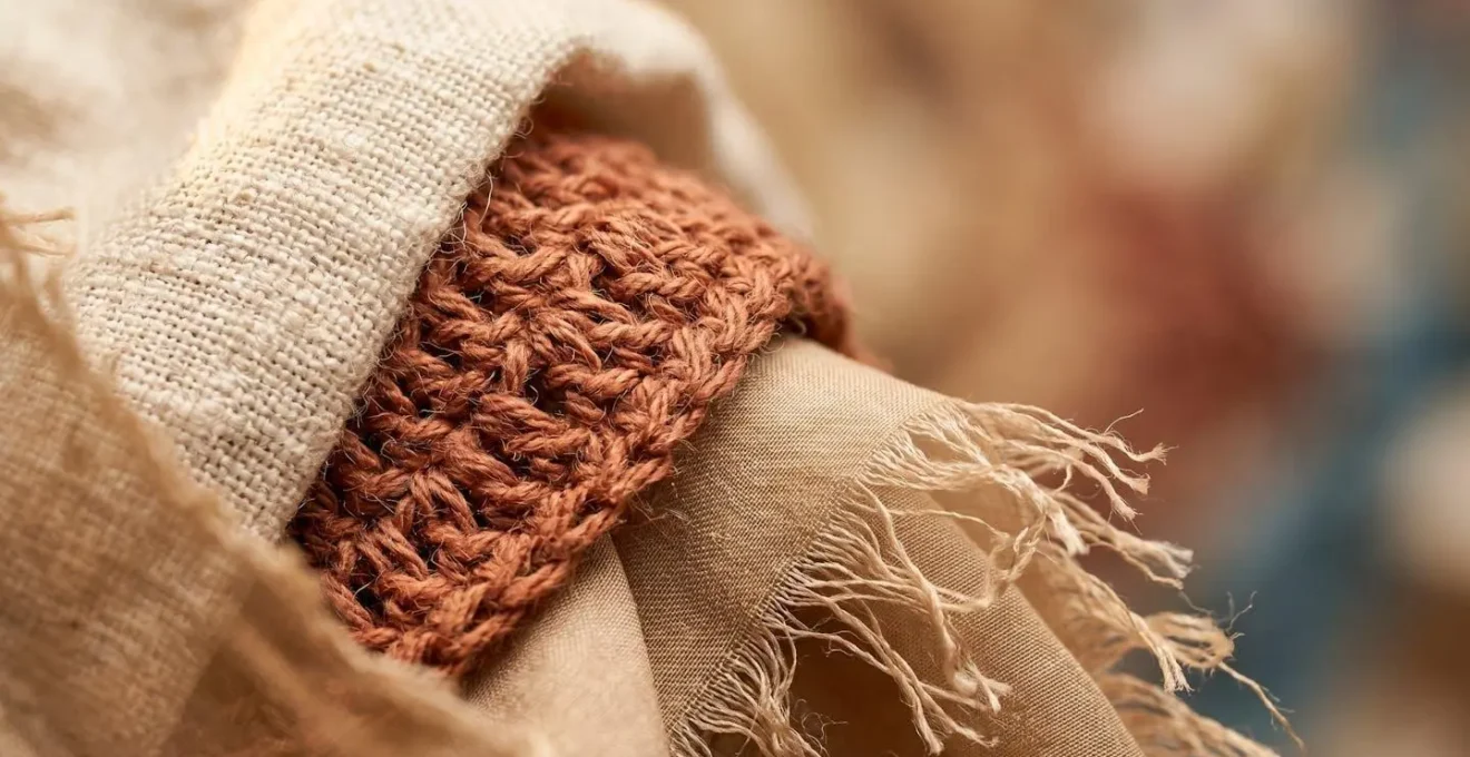 Detalle de capas de ropa bohemia superpuestas mostrando texturas de lino y algodón